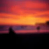 Vibrant sunset over Huntington Beach with surfers catching waves