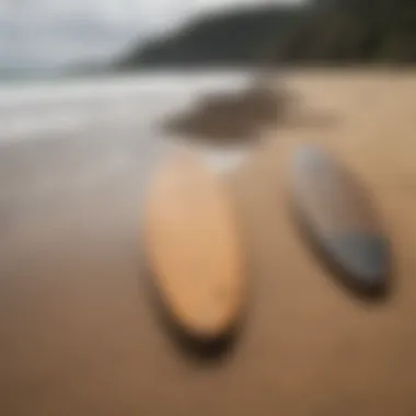 Side-by-side comparison of traditional and surftech longboards on a sandy beach.