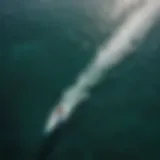 Aerial view of an electric foil surfer gliding over a crystal-clear ocean.