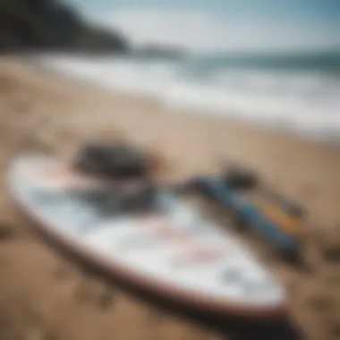 Close-up of essential paddleboarding gear laid out on the beach