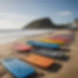 A vibrant assortment of boogie boards on the beach showcasing various designs and colors