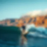 Surfer riding a wave against a backdrop of Iceland's rugged coastline