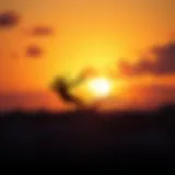 A dynamic kitesurfer showcasing an Ozone kite in action against a vibrant sunset backdrop