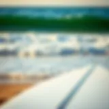 Surfboard on the beach with waves in the background