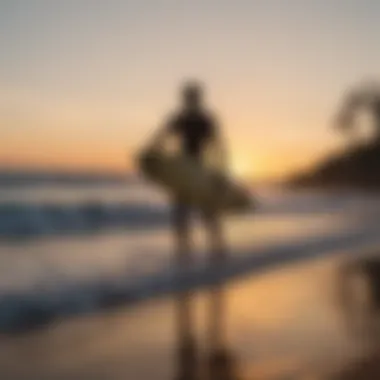 A sunset silhouette of a surfer on the beach