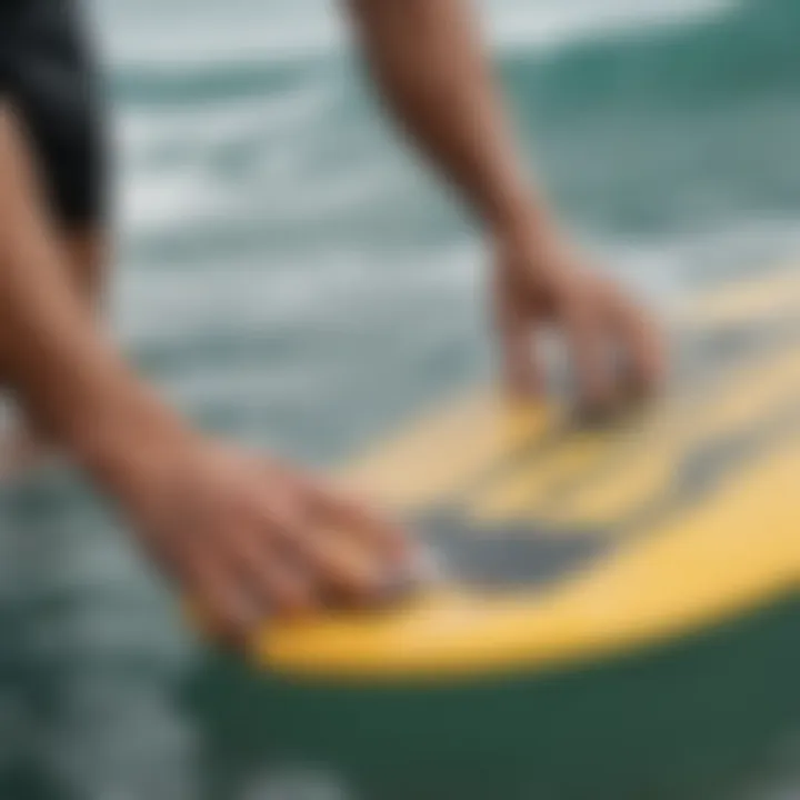 Surfer applying maintenance products to a grip pad