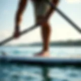 A paddleboarder adjusting paddle height for optimal performance